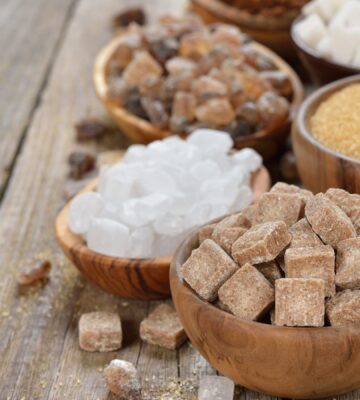 Different types of sugars in wooden bowls to illustrate article about the healthiest vegan sweeteners