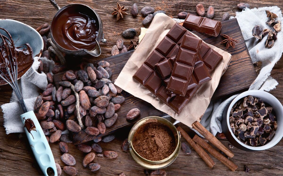 Cacao beans, powder, cacao butter, chocolate bar and chocolate sauce to illustrate the health benefits of chocolate