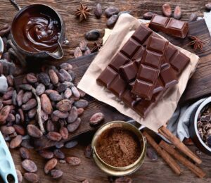 Cacao beans, powder, cacao butter, chocolate bar and chocolate sauce to illustrate the health benefits of chocolate