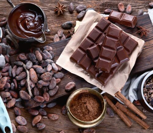 Cacao beans, powder, cacao butter, chocolate bar and chocolate sauce to illustrate the health benefits of chocolate