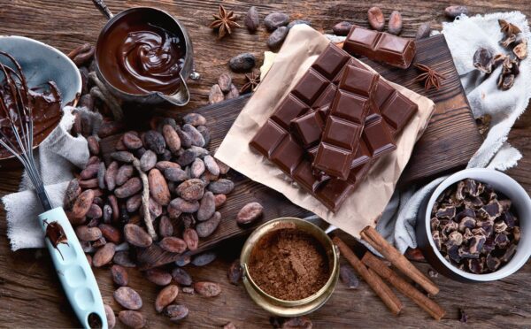 Cacao beans, powder, cacao butter, chocolate bar and chocolate sauce to illustrate the health benefits of chocolate