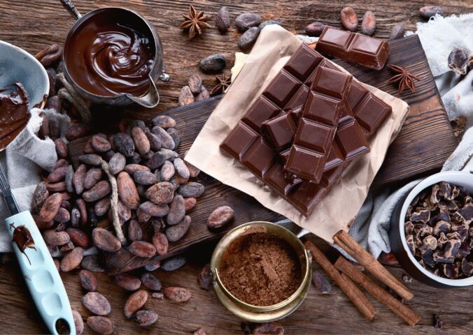 Cacao beans, powder, cacao butter, chocolate bar and chocolate sauce to illustrate the health benefits of chocolate