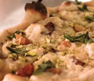 Baked pizza from Millennium restaurant topped with Miyoko's fermented vegan mozzarella that has melted and set in the oven