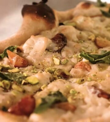 Baked pizza from Millennium restaurant topped with Miyoko's fermented vegan mozzarella that has melted and set in the oven