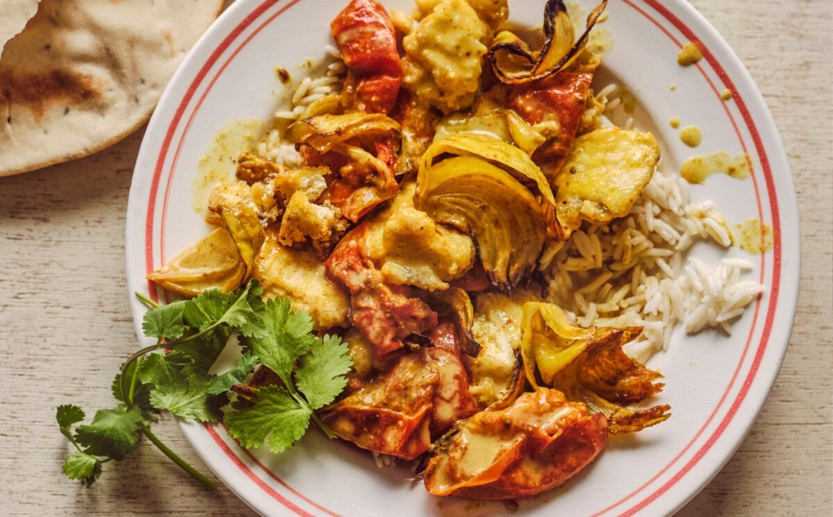 a bowl of creamy roasted tomatoey tofu curry with coriander for high-protein recipes for winter