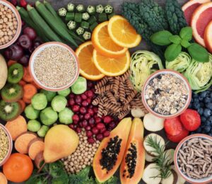 Photo shows a colorful mosaic of fresh fruit, vegetables, nuts, seeds, and other nutrient-dense plant-based foods. Hundreds of doctors and nutrition researchers have called for a return to evidence-based recommendations in the 2025–2030 Dietary Guidelines for Americans (DGA), including the prioritization of plant-based foods over high-impact meat and dairy