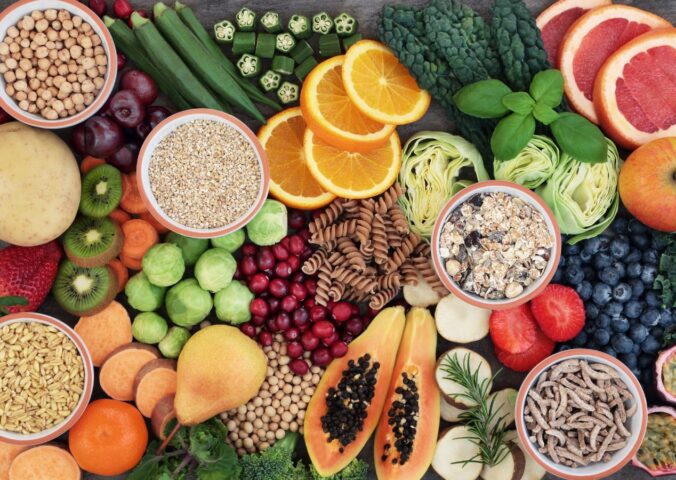 Photo shows a colorful mosaic of fresh fruit, vegetables, nuts, seeds, and other nutrient-dense plant-based foods. Hundreds of doctors and nutrition researchers have called for a return to evidence-based recommendations in the 2025–2030 Dietary Guidelines for Americans (DGA), including the prioritization of plant-based foods over high-impact meat and dairy
