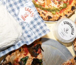 Photo shows Casadei's Stracciatella in a large block, in a tub, and on top of a selection of fresh vegan pizzas. The UK's Everyman Cinemas has added Casadei Foods' vegan Stracciatella to the pizza menu nationwide