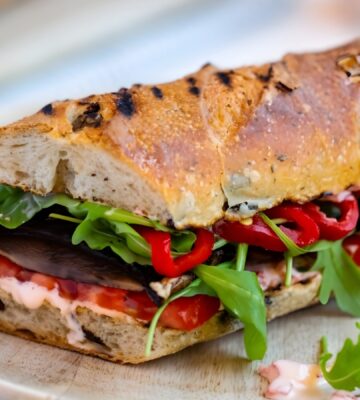 grilled portobello and roasted red pepper sandwich with salad, tomatoes, and shoyu