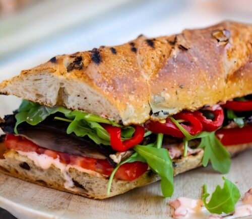 grilled portobello and roasted red pepper sandwich with salad, tomatoes, and shoyu