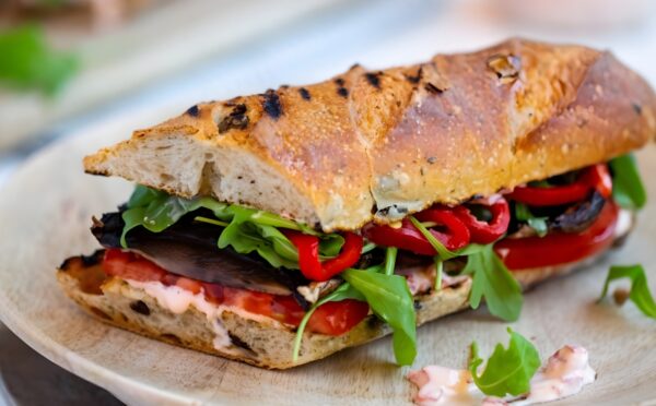 grilled portobello and roasted red pepper sandwich with salad, tomatoes, and shoyu