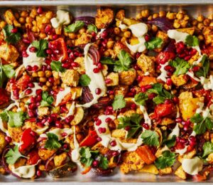 harissa tofu veggie traybake with creamy cashew sauce and pomegranates