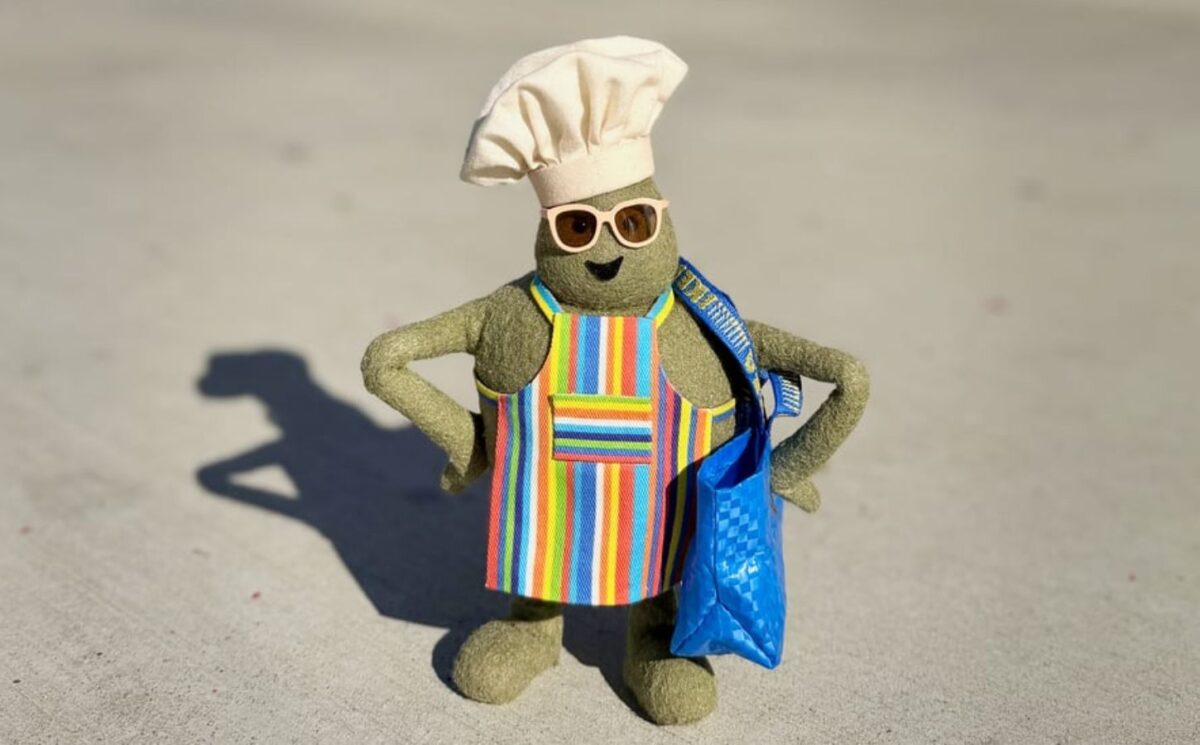 Photo shows "The Chef," the star of 'The Tiny Chef Show,' standing outside of an IKEA and wearing a tiny blue IKEA bag. IKEA has just introduced a new vegan-friendly falafel ball, inspired by its classic meatballs, in collaboration with 'The Tiny Chef Show'