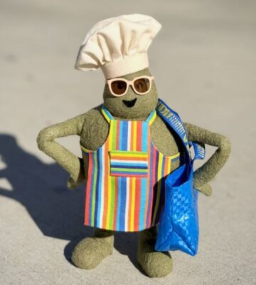 Photo shows "The Chef," the star of 'The Tiny Chef Show,' standing outside of an IKEA and wearing a tiny blue IKEA bag. IKEA has just introduced a new vegan-friendly falafel ball, inspired by its classic meatballs, in collaboration with 'The Tiny Chef Show'