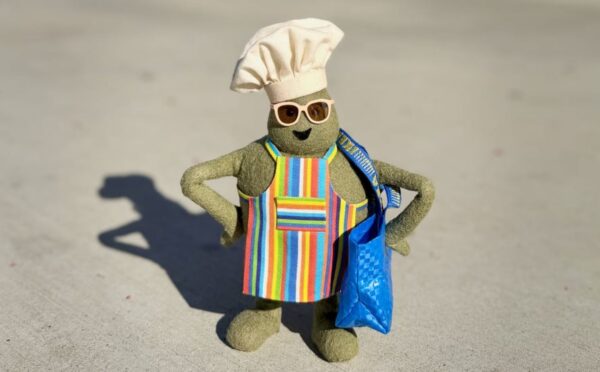 Photo shows "The Chef," the star of 'The Tiny Chef Show,' standing outside of an IKEA and wearing a tiny blue IKEA bag. IKEA has just introduced a new vegan-friendly falafel ball, inspired by its classic meatballs, in collaboration with 'The Tiny Chef Show'