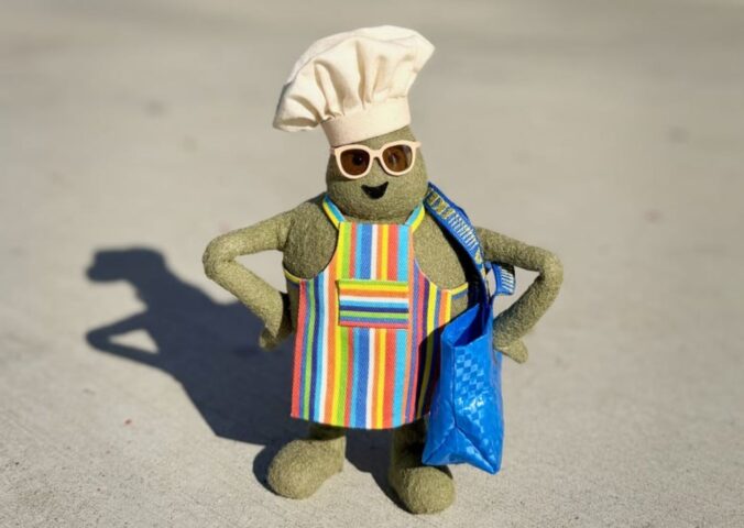 Photo shows "The Chef," the star of 'The Tiny Chef Show,' standing outside of an IKEA and wearing a tiny blue IKEA bag. IKEA has just introduced a new vegan-friendly falafel ball, inspired by its classic meatballs, in collaboration with 'The Tiny Chef Show'