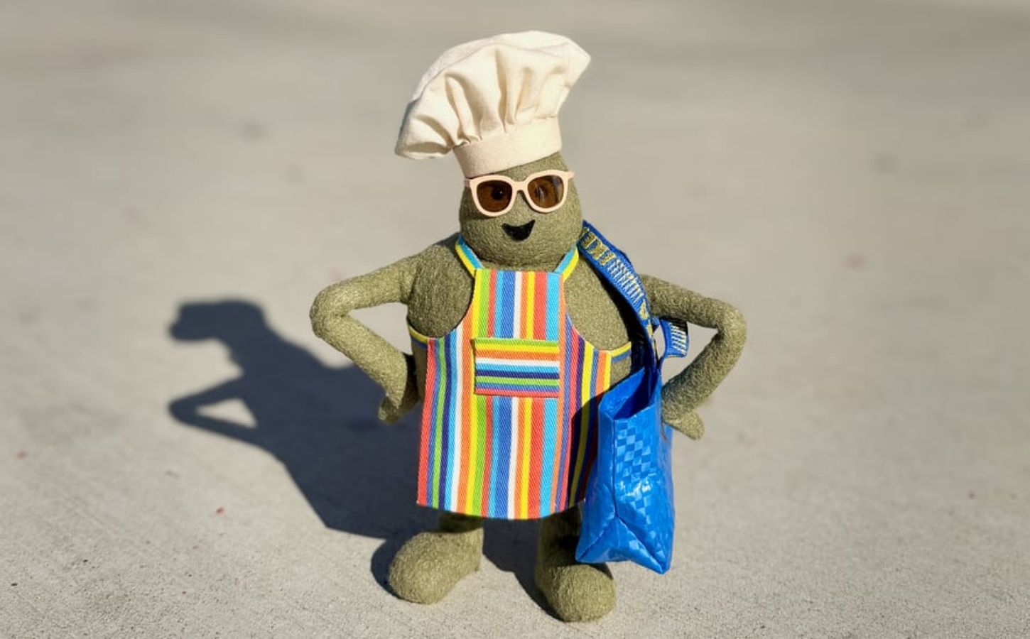 Photo shows "The Chef," the star of 'The Tiny Chef Show,' standing outside of an IKEA and wearing a tiny blue IKEA bag. IKEA has just introduced a new vegan-friendly falafel ball, inspired by its classic meatballs, in collaboration with 'The Tiny Chef Show'
