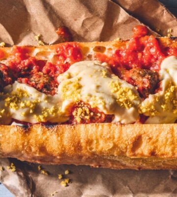 a vegan meatball parmigiana hero with cashew mozzarella, lentil meatballs, and basil for recipes that use nutritional yeast