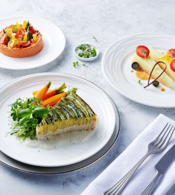 Photo shows the zucchini tart, which is one of the nearly 500 plant-based options now available on Emirates flights. The airline is doubling down on vegan airplane food in 2026