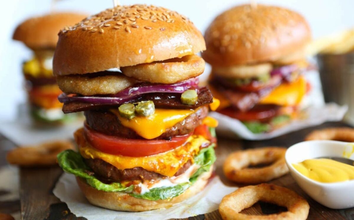 a meat-free mega burger stacked with dairy-free cheese, salad, and onion rings for recipes that aren't bowls or salads