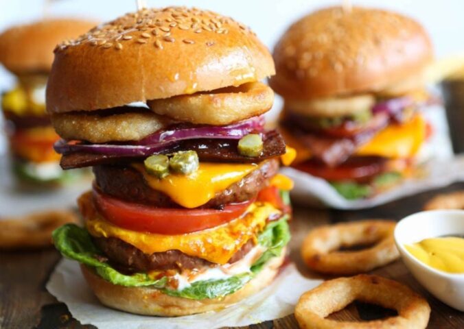 a meat-free mega burger stacked with dairy-free cheese, salad, and onion rings for recipes that aren't bowls or salads