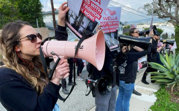 Photo shows CAFT activists demonstrating, including one person holding a bullhorn and another holding a placard. Wella announced that it will no longer sponsor Milan Fashion Week following recent protests and public pressure over fur.