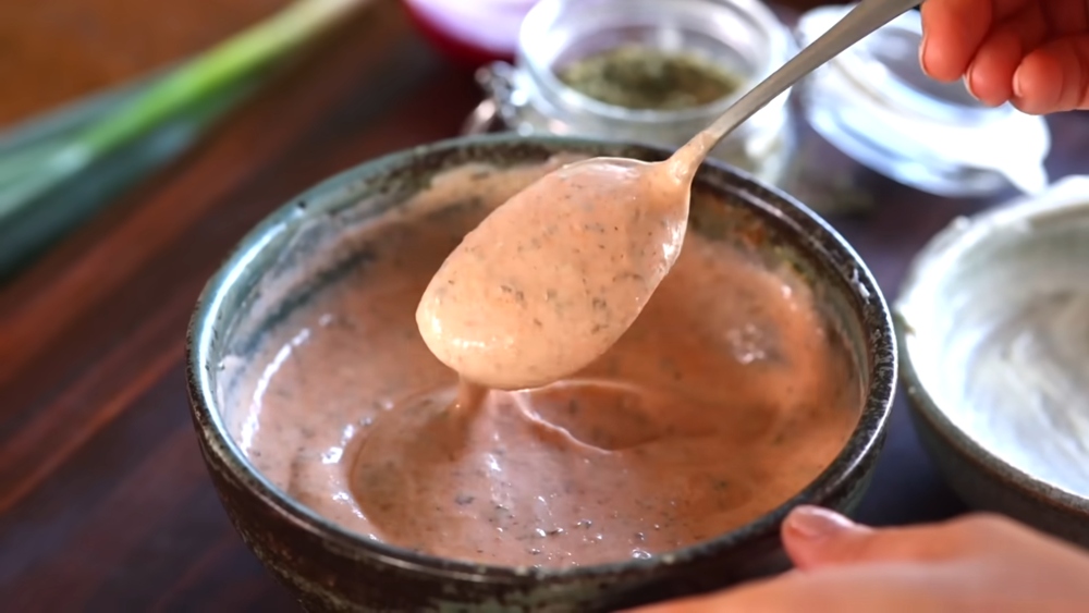 Shot of the pasta salad dressing containing vegan mayo, yogurt, and hot sauce, to illustrate article about budget-friendly plant-based recipes