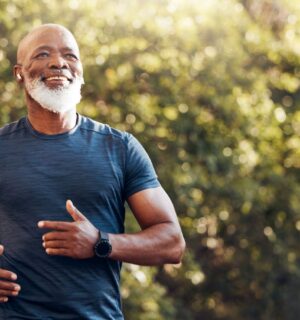 Smiling man running in a park, to illustrate article that answers this question: can a plant-based diet reverse atherosclerosis?