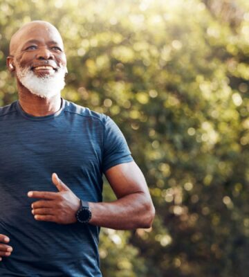 Smiling man running in a park, to illustrate article that answers this question: can a plant-based diet reverse atherosclerosis?