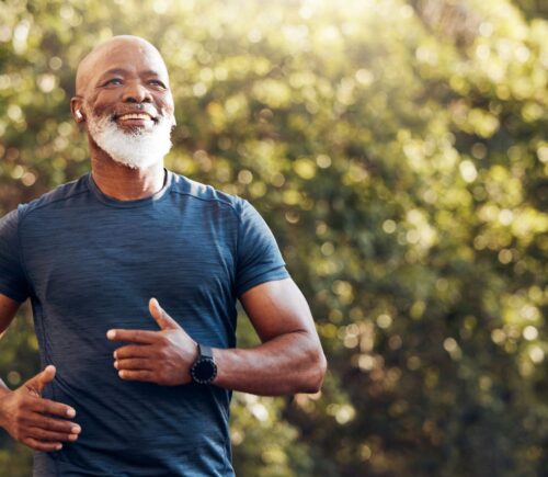 Smiling man running in a park, to illustrate article that answers this question: can a plant-based diet reverse atherosclerosis?