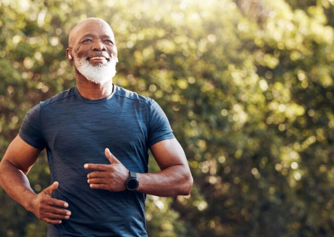 Smiling man running in a park, to illustrate article that answers this question: can a plant-based diet reverse atherosclerosis?