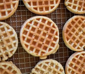 Freshly made oat waffles cooling on a wire rack as part of freezer friendly vegan meals prep