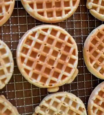Freshly made oat waffles cooling on a wire rack as part of freezer friendly vegan meals prep