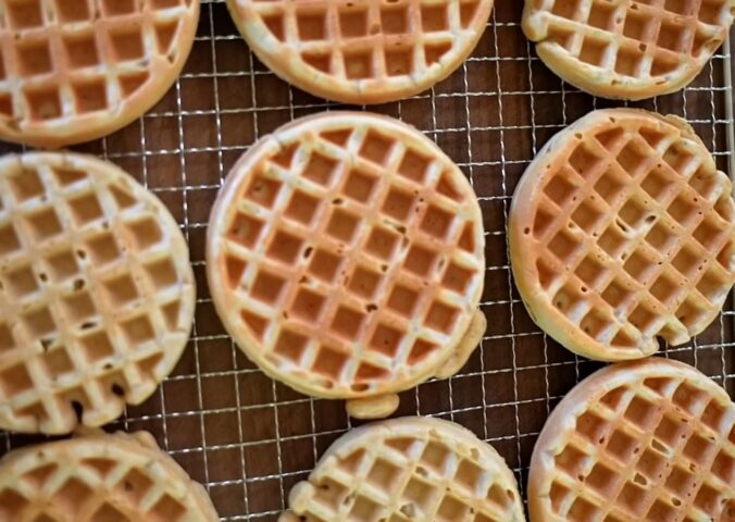 Freshly made oat waffles cooling on a wire rack as part of freezer friendly vegan meals prep