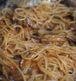 Shot of Miyoko's pasta in her cast iron pan with her winter pasta sauce made with frozen tomatoes and smoked shiitake mushrooms