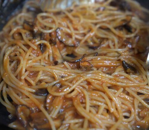 Shot of Miyoko's pasta in her cast iron pan with her winter pasta sauce made with frozen tomatoes and smoked shiitake mushrooms