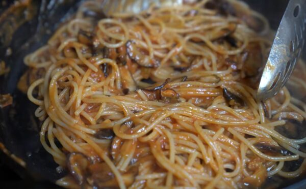 Shot of Miyoko's pasta in her cast iron pan with her winter pasta sauce made with frozen tomatoes and smoked shiitake mushrooms