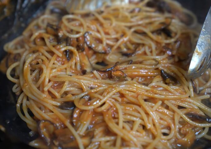 Shot of Miyoko's pasta in her cast iron pan with her winter pasta sauce made with frozen tomatoes and smoked shiitake mushrooms