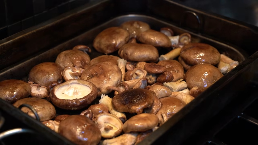 Shiitake mushrooms smoking over wood chips for a smoky umami element in Miyoko's winter pasta sauce