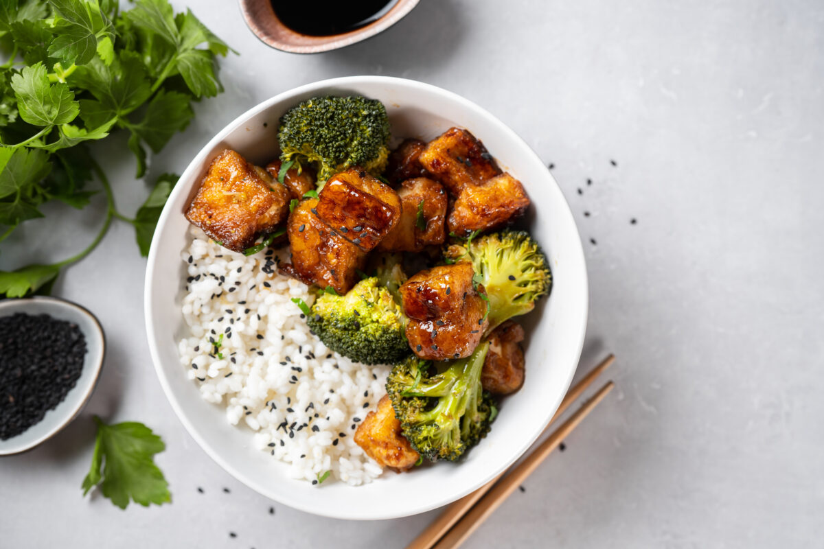 Photo shows a nutritious rice bowl meal with brocolli, tofu, dipping sauce, and rice. Carnivore diet advocate Eddie Abbew says that tofu “is not food.”