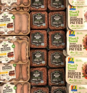 Photo shows a large refrigerator full of plant-based burgers, sausages, and other meat-alternatives, including several products made by Beyond Meat