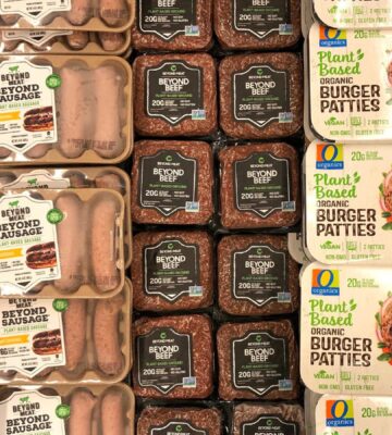 Photo shows a large refrigerator full of plant-based burgers, sausages, and other meat-alternatives, including several products made by Beyond Meat