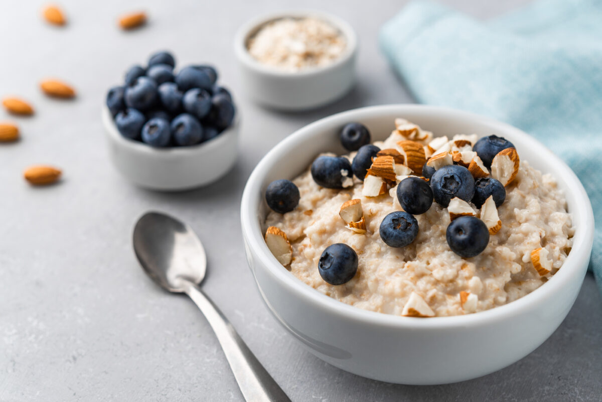 Photo shows a bowl of porridge topped with nuts and blueberries. 'Greener By Default' Hospitals Reduced Food Emissions By 22% With Plant-Based Meals
