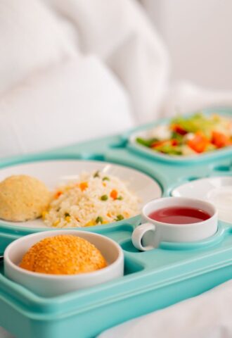 Photo shows someone eating a healthy, plant-based hospital meal in bed. A catering company has reduced hospital food emissions by 22 percent over the last year with “Greener By Default” plant-based meals