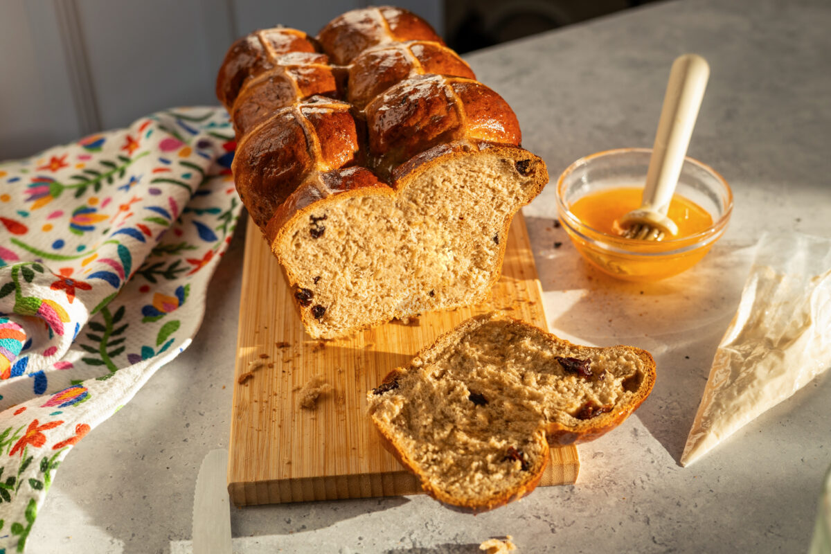 vegan hot cross bun loaf with raisins and an apricot jam glaze