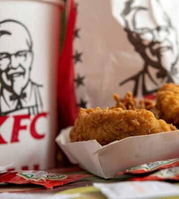 Photo shows a box of KFC chicken in front of KFC branded packaging. Several major fast-food brands have scrapped a key animal welfare pledge to move away from “frankenchickens,” including Nando’s and KFC.