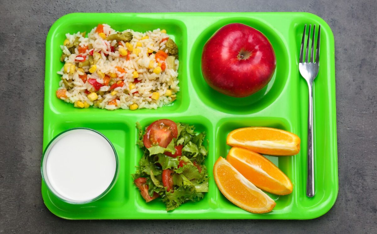 Photo shows a green cafeteria tray with fruit, vegetables, and salad on it. Children and young people in Poland are now guaranteed access to plant-based school meals for the first time ever