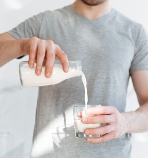 Photo shows a man pouring a glass of milk from a bottle. A new AHDB report claims that dairy is beneficial for both human health and the environment, but food advocacy NGO ProVeg described the findings as "another exercise in marketing over health and evidence"