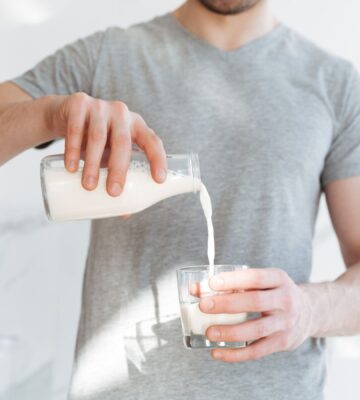 Photo shows a man pouring a glass of milk from a bottle. A new AHDB report claims that dairy is beneficial for both human health and the environment, but food advocacy NGO ProVeg described the findings as "another exercise in marketing over health and evidence"