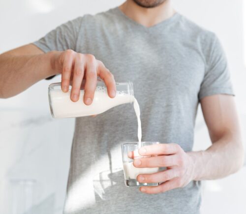 Photo shows a man pouring a glass of milk from a bottle. A new AHDB report claims that dairy is beneficial for both human health and the environment, but food advocacy NGO ProVeg described the findings as "another exercise in marketing over health and evidence"